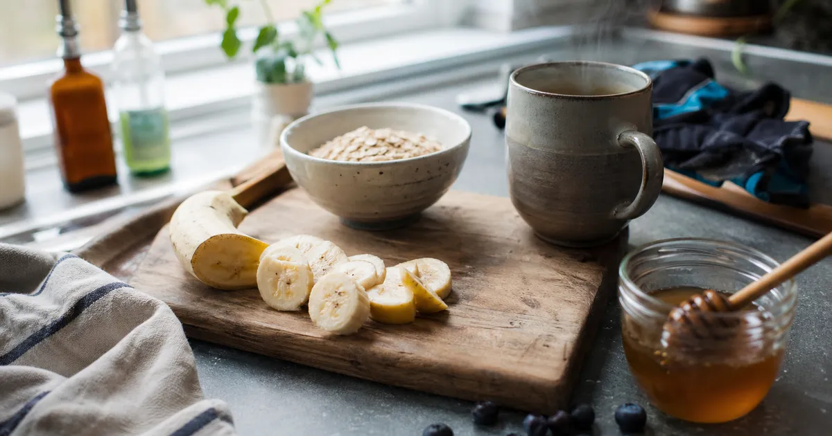 Frukostförberedelser med havregryn, banan och blåbär på köksbänk