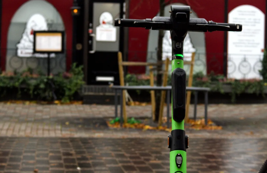 Elsparkcykel ligger vält på en cykelbana en mörk kväll