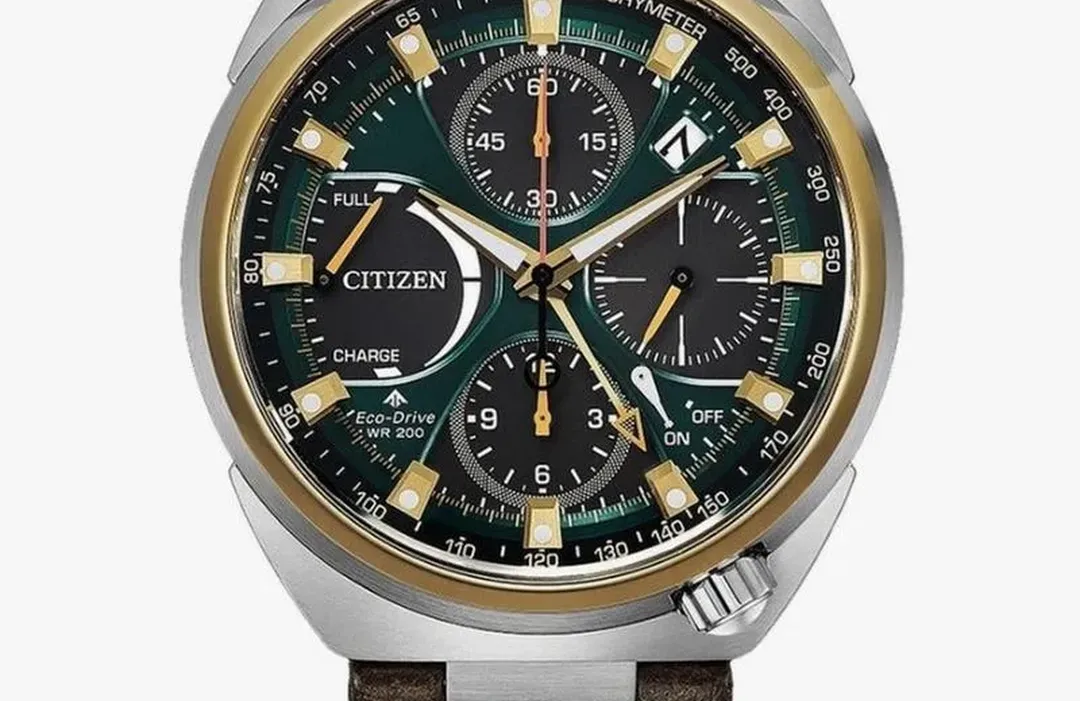 Citizen Promaster Tsuno Chrono Racer kronograf med silverfärgat stålhölje, guldtoner, mörk grönsvart urtavla, brunläderarmband och tachymeterskala.